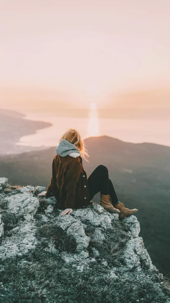 Mujer mirando el horizonte desde una montaña